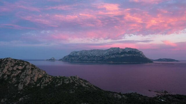 View from above, stunning aerial view of Tavolara Island in the distance during a beautiful sunset. Capo Ceraso, Sardinia, Italy.