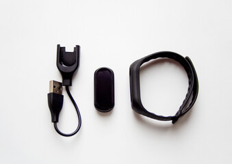 Black fitness tracker device mockup with charging USB cable and wrist band isolated on white background