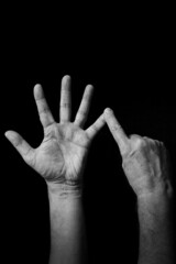 B+W image of hand demonstrating BSL sign language letter U isolated against black background
