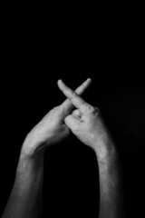 B+W image of hand demonstrating BSL sign language letter X isolated against black background