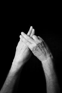 B+W image of hand demonstrating BSL sign language letter F isolated against black background