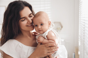 Happy young mother with her cute baby at home