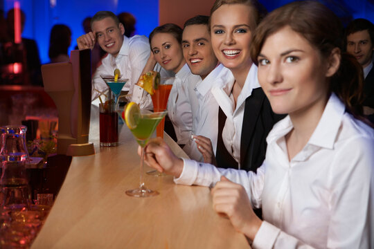 Portrait of coworkers with drinks at bar after work