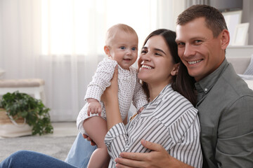 Happy family with their cute baby in living room at home