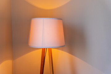 shining lamp on the table near bed.Table lamp dimly shines on the table in the bedroom.Light gleam, shine warm room