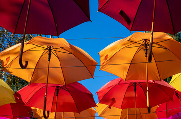 many colorful umbrellas hanging in the park