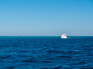 Yachts with tourists sail on the beautiful blue surface of the sea.