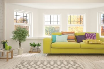 Stylish room in white color with sofa and autumn landscape in window. Scandinavian interior design. 3D illustration