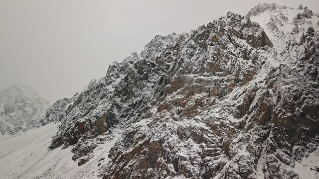 Storm, snowfall in the huge glacier of Mount Belukha, the valley of the Aktru River, the Altai Mountains. Cloudy weather, stone in the snow, storm, wildlife, winter forest, frozen mountain river in