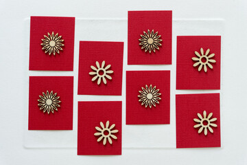 christmas card with snowflakes or flowers or starbursts on red paper squares