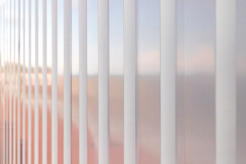 Shiny white ridged metal wall with colorful reflections