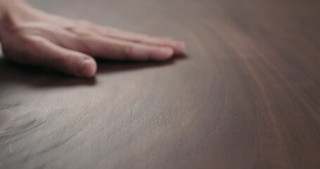 Slow motion of man hand checking toned walnut table surface with oil finish - Powered by Adobe