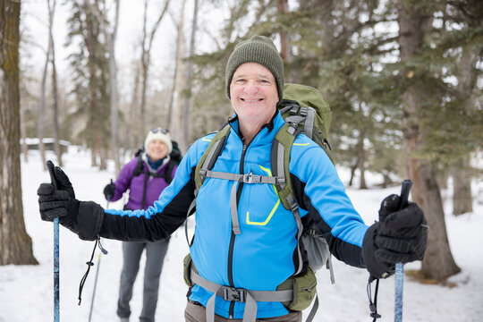 Portrait happy confident senior man cross country skiing in park