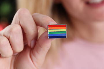 Woman holding icon with lgbt flag in her hands closeup