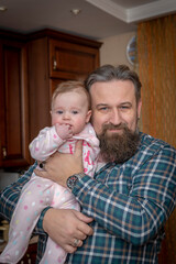 bearded dad with a little daughter in his arms