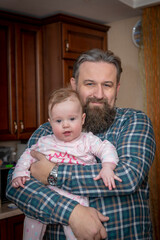 bearded dad with a little daughter in his arms