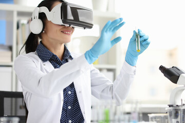 Woman scientist chemist in virtual reality glasses holding test tube in laboratory