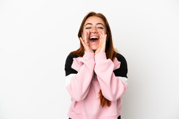 Young redhead woman isolated on white background shouting and announcing something
