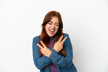 Fototapeta premium Young redhead woman isolated on white background smiling and showing victory sign