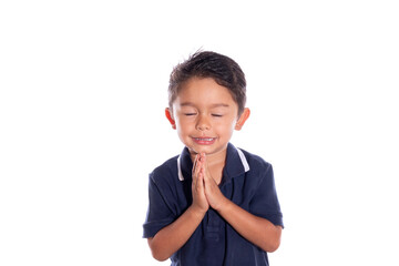 Boy asking for forgiveness with closed eyes, isolated on white background. Latin boy joins hands...