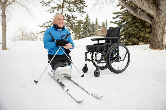 Portrait of cheerful senior sit-skier in winter