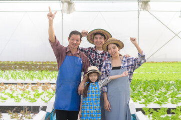 Happy farmer family working in hydroponic greenhouse farm, clean food and healthy eating concept