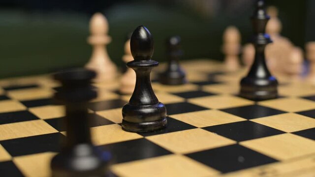battle of figures on a chessboard, close-up, black bishop wins white pawn