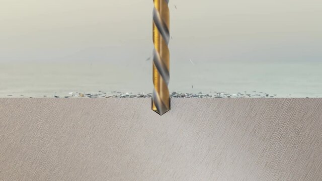 Gold twist drill bit boring a hole into a brushed metal plate