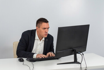 caucasian man working at the computer on a white background.