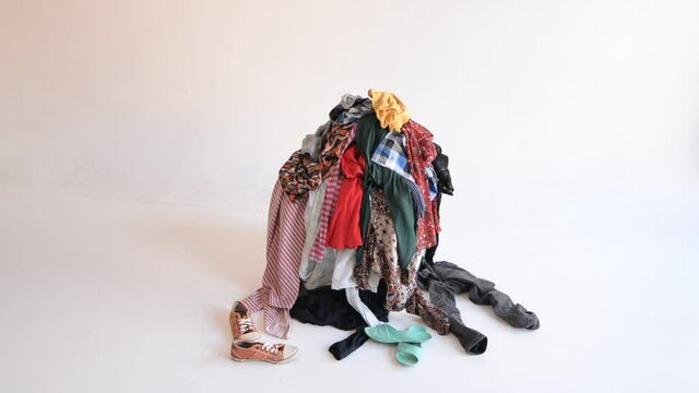 Pile of used clothes that other things are thrown at. Waste sorting and recycling