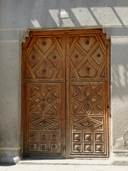 Textured vintage door in Avila, Spain. Closed wooden entrance with elegant ornament