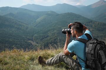 Professional photographer taking picture with modern camera in mountains. Space for text