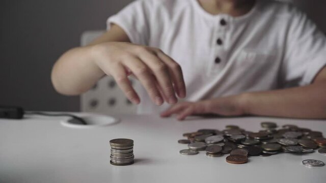 boy making pyramide of coins. ABC of finance. boy counting money