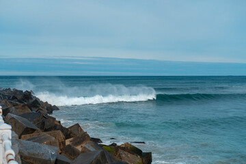 Sea waves and rocks. Seasore. Basque country landscape. Rainy weather. Blue water and sky.