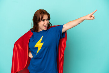Young caucasian woman isolated on white background in superhero costume with proud gesture © luismolinero