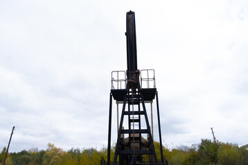 Oil pump oil rig energy industrial machine for petroleum. Wind power plantson background. Safe extraction of resources.