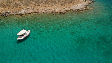Aerial drone photo of inflatable boat anchored in tropical Caribbean turquoise bay with calm sea