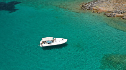 Aerial drone photo of inflatable boat anchored in tropical Caribbean turquoise bay with calm sea