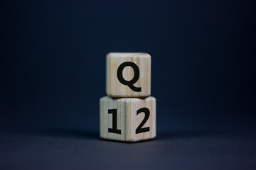 From 1st to 2nd quarter symbol. Turned wooden cubes and changed words 'Q1' to 'Q2'. Beautiful grey table, grey background. Business, happy 2nd quarter Q2 concept, copy space.