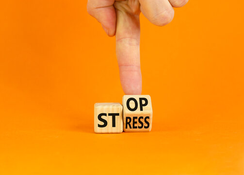 Stop stress and be health symbol. Doctor turns a wooden cube and changes words 'stress' to 'stop'. Beautiful orange background. Psychological, business and stop stress concept. Copy space.