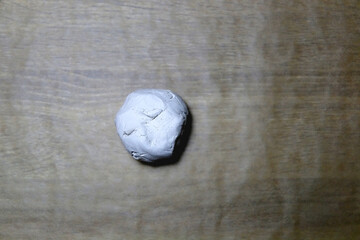 Ball of air dry clay on parchment paper. Making crafts at home. Top view.