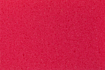 background of red sponge for washing dishes, close-up, porous surface