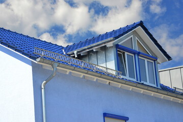Sattelgaube, Seitengiebel mit Stehfalz-Metallverkleidung der Seitenwange auf mit blauen Ziegeln gedeckten Ziegeldach als Wetterschutz  © Hermann