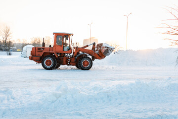 Cleaning snow drifts with a bulldozer. A bulldozer removes snow with a bucket after a blizzard. ...