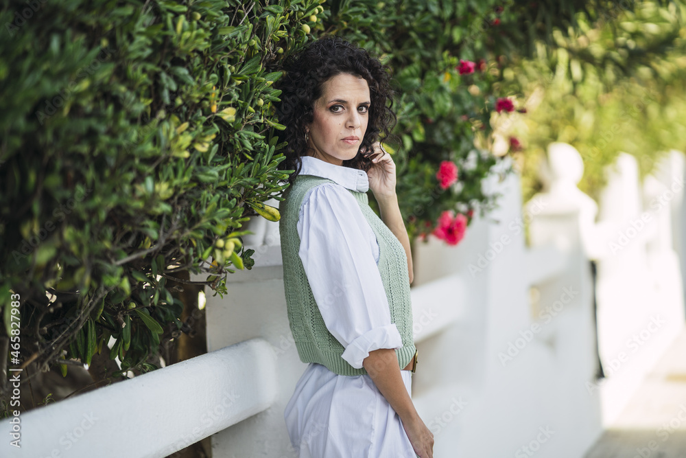 Canvas Prints Vertical shot of a Spanish female posing in front of the white gate