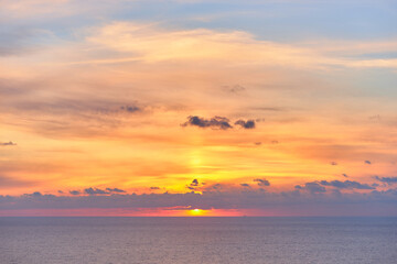 Sunrise at sea with clouds in the sky and blue and orange colors