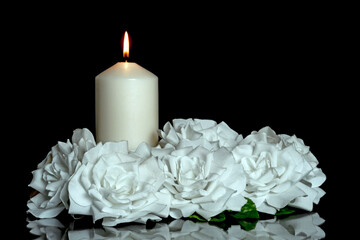 LIGHTED CANDLE AND WHITE ROSES ARRANGEMENT ON DARK BACKGROUND. CONDOLENCE CARD FOR ALL SOULS DAY.