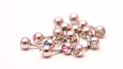 A set of jewelry for piercing on a white background. A set of earrings for the body, nose, navel, tongue, nipples, ears, various beauty jewelry, a set of cosmetological jewelry for piercing.
