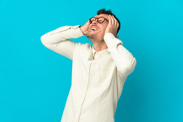 Young caucasian handsome man isolated on blue background stressed overwhelmed