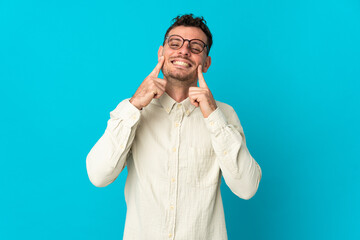 Young caucasian handsome man isolated on blue background smiling with a happy and pleasant expression